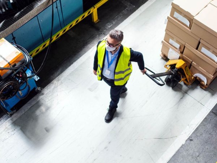 Addetto alla logistica movimenta un pallet nello stabilimento